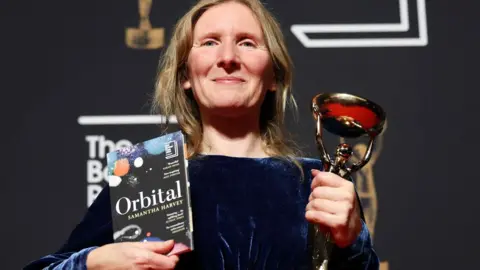 EPA Samantha Harvey holding Booker Prize award