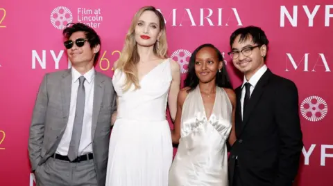 Getty Images (L-R) Pax Thien Jolie-Pitt, Angelina Jolie, Zahara Marley Jolie and Maddox Chivan Jolie-Pitt pose at the New York Film Festival premiere of Maria in September 2024