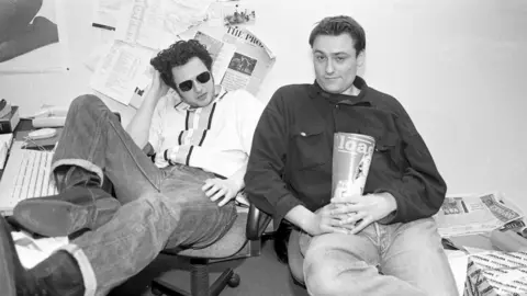 Martyn Goodacre/Getty James Brown (left) and Tim Southwell (right) holding a mock-up of the first ever Loaded magazine in 1994 in a black and white photo