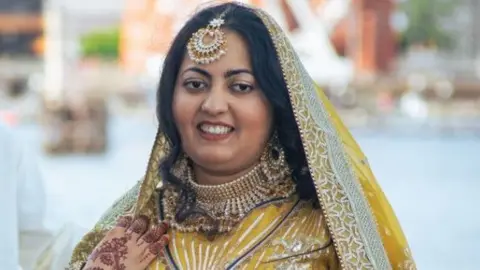 Anum Munawar Anum, wearing a gold Bollywood dance costume with henna tattooed on one hand