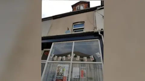 Charlie Lambert 14 St George's Terrace. It is a three-storey beige house with large front windows and an attic room window. 