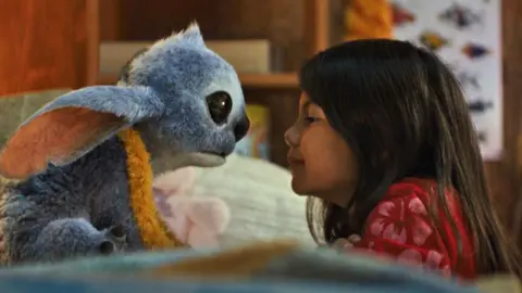 Disney Furry alien Stictch nose-to-nose with young girl Lilo in a still from the Lilo and Stitch remake
