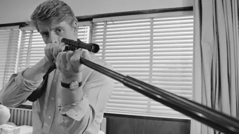 Getty Images Edward Fox in The Day of the Jackal. He is looking into the sights of his rifle.