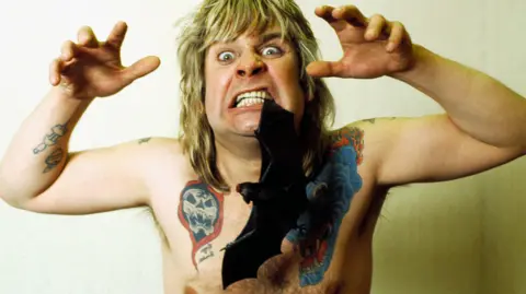 Alamy Ozzy Osbourne and a rubber bat