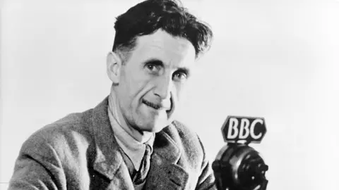 BBC A black and white portrait of George Orwell in front of a BBC microphone
