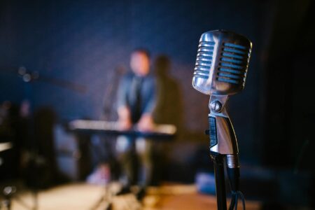How Poetry Slams Are Drawing Bigger Crowds Than Stand-Up Comedy Close-up of microphone on stage with dramatic lighting for live performance