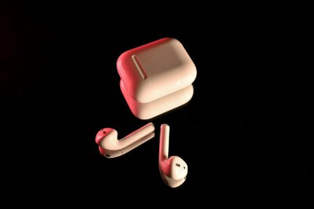 Modern wireless earbuds on a white surface showing sleek design and charging case