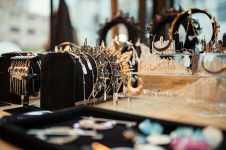 Close-up of delicate gold jewelry pieces including rings and earrings on white background