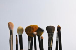 Professional makeup brushes and cosmetic products arranged on clean surface