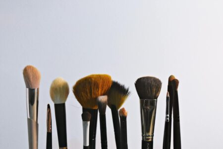Professional makeup brushes and cosmetic products arranged on clean surface
