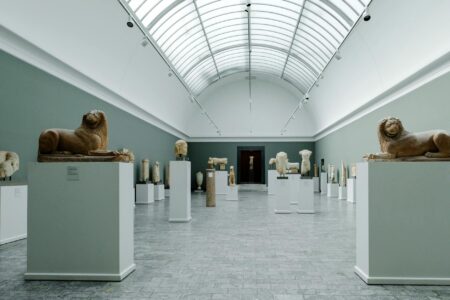 Modern museum gallery with visitors viewing artwork on white walls