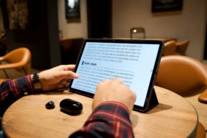 How Kindle Unlimited Is Changing What Authors Actually Write Person reading an e-book on tablet device showing digital reading interface