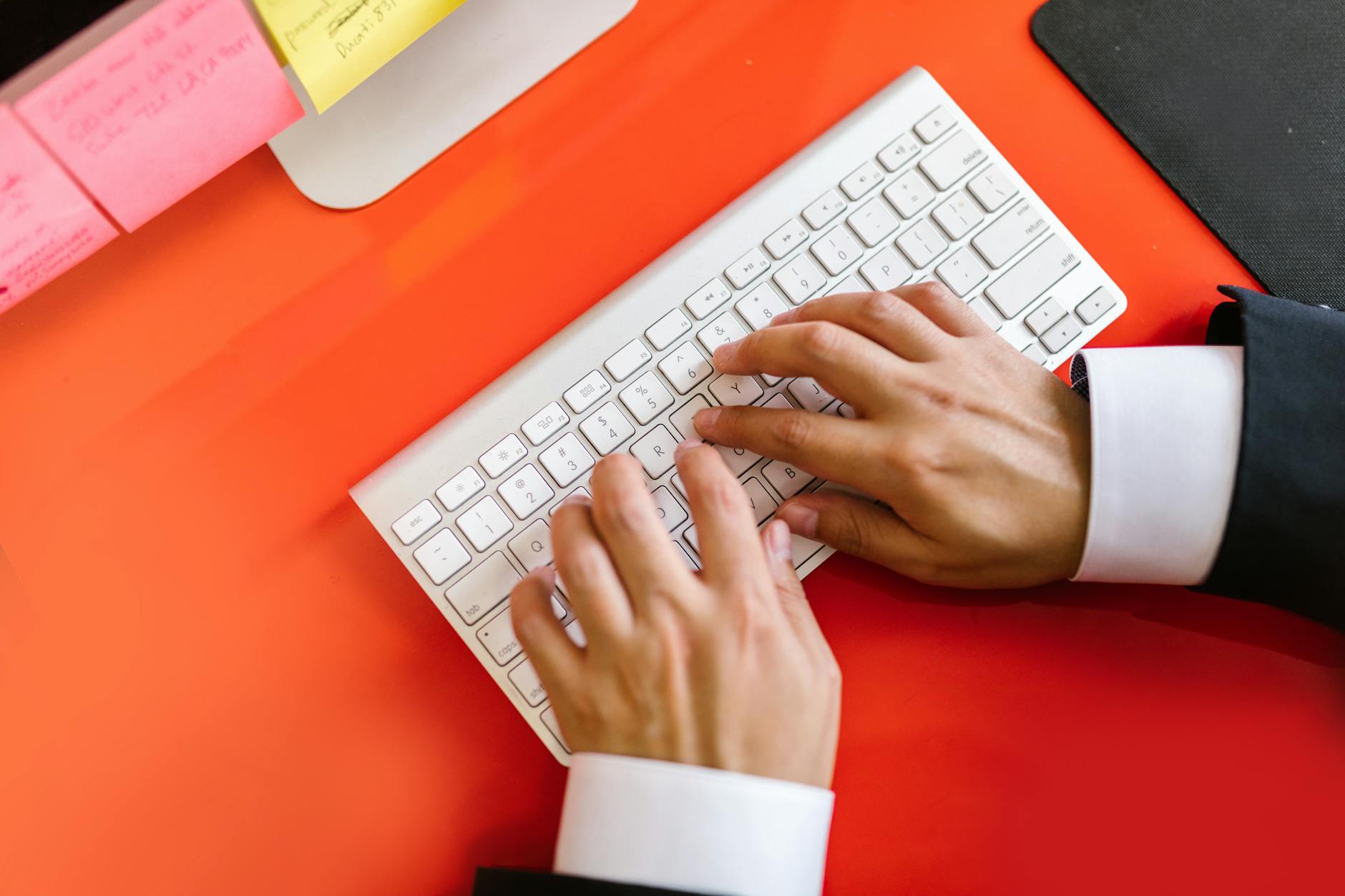 Hands typing on a mechanical keyboard with tablet setup