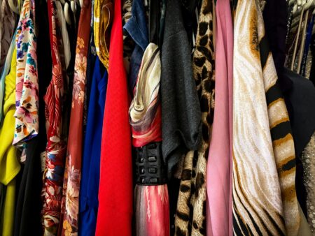 Colorful vintage clothing items hanging on racks, representing the secondhand fashion marketplace