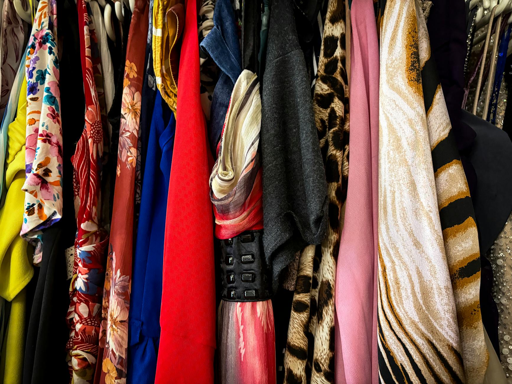 Colorful vintage clothing items hanging on racks, representing the secondhand fashion marketplace