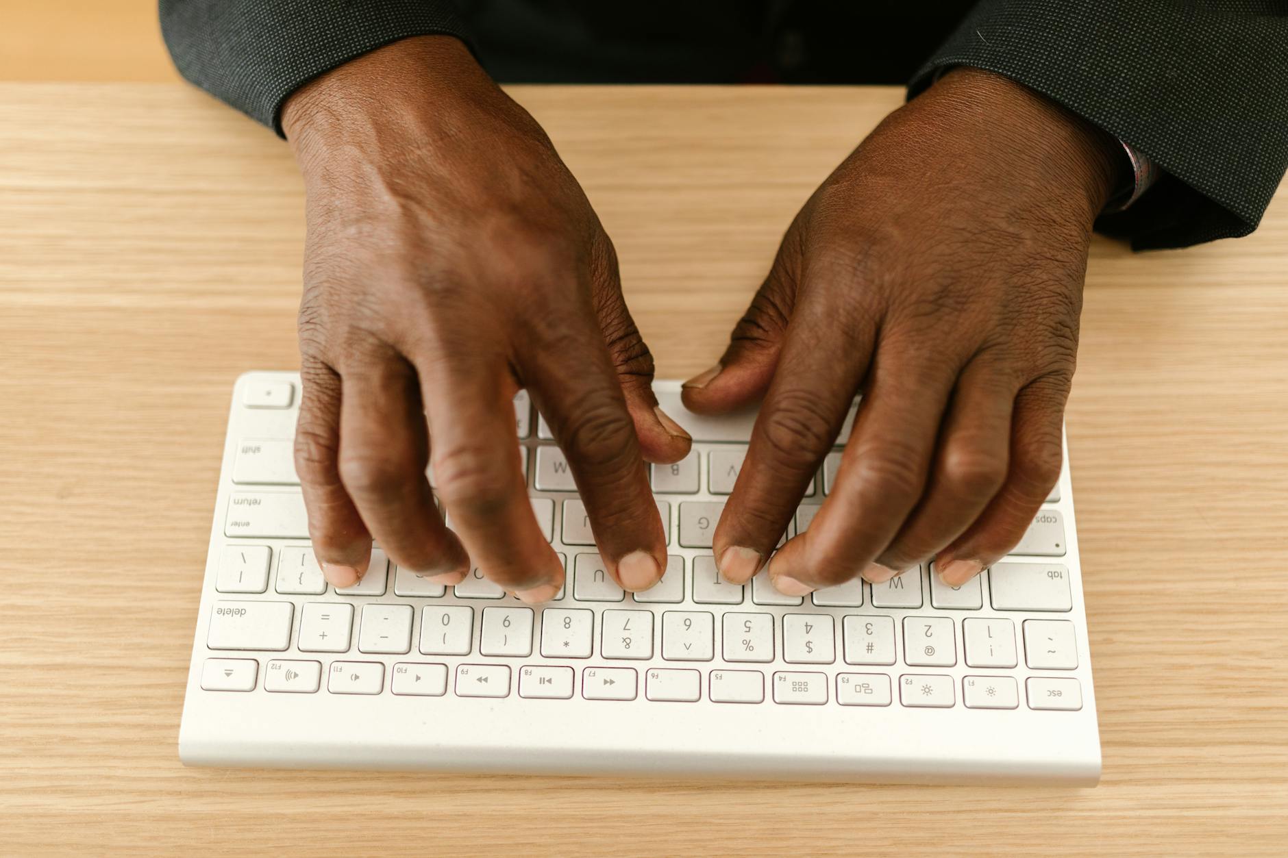 Hands typing on mechanical keyboard in modern office environment