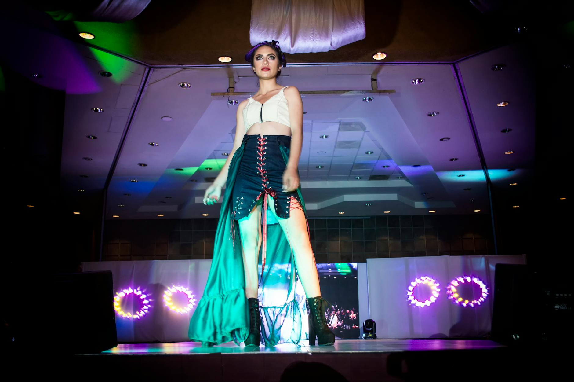Fashion models walking down a runway displaying contemporary designer clothing to seated audience