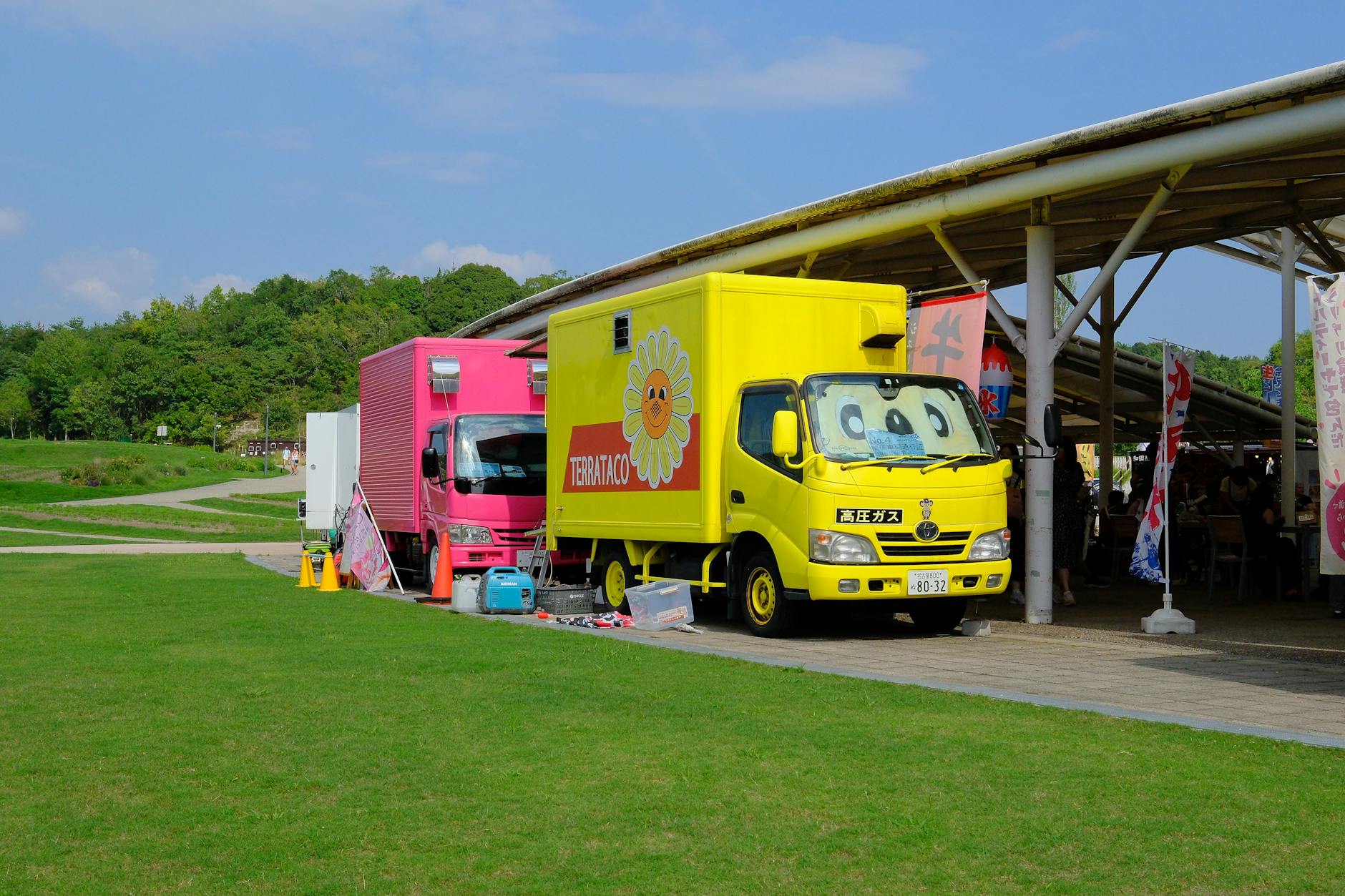 Colorful food trucks lined up at outdoor event venue serving customers