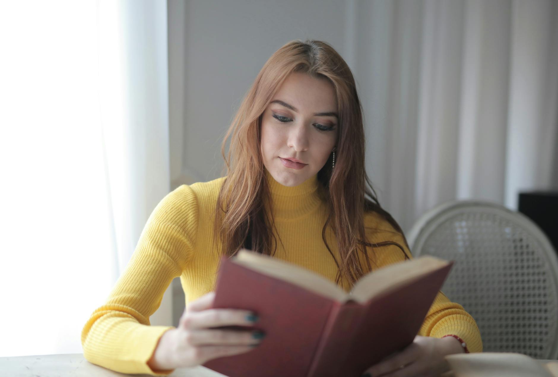 Person reading book with focused concentration, representing audiobook preparation