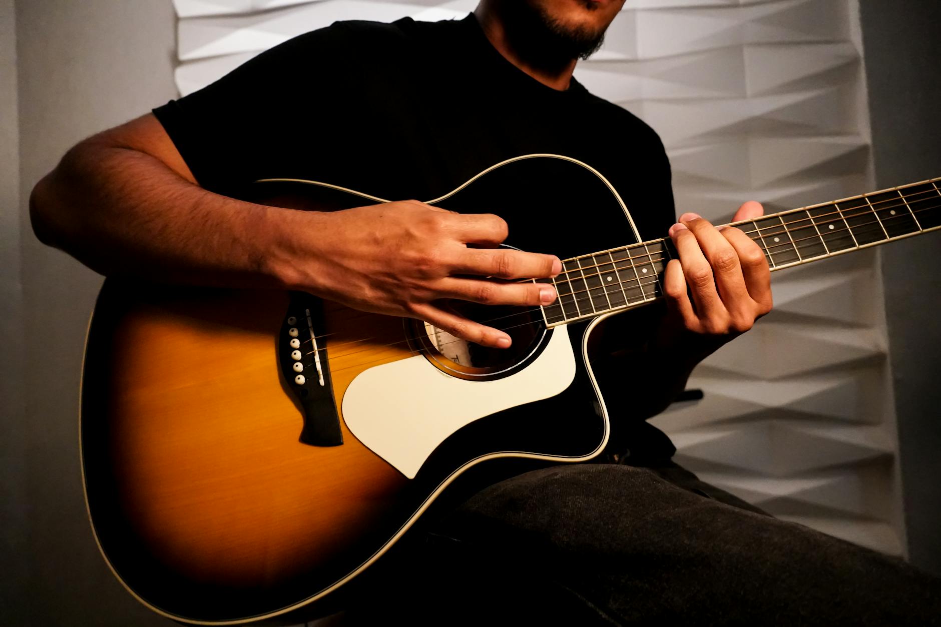 Musician performing acoustic guitar in casual intimate setting with small audience