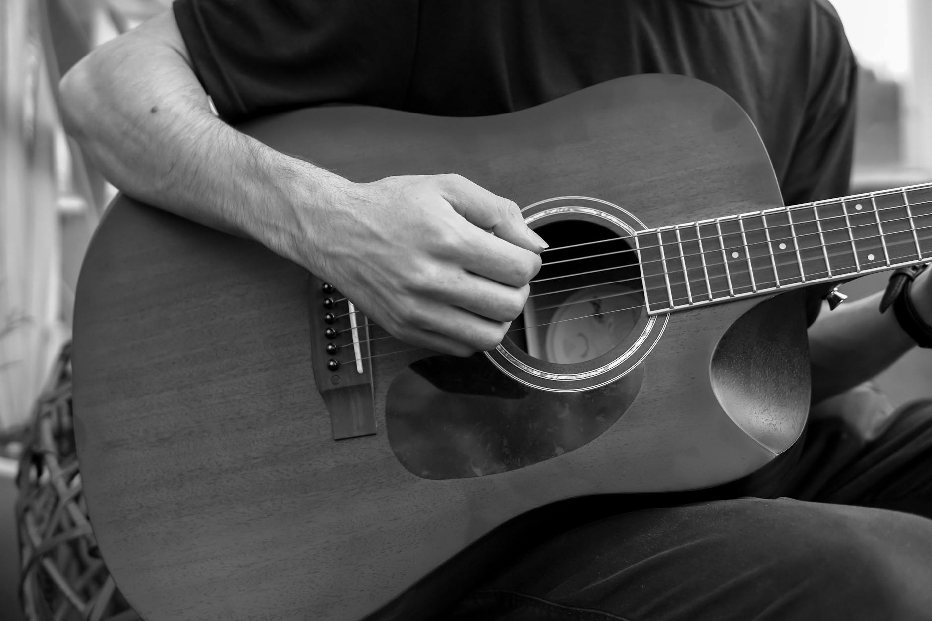 Musician playing acoustic guitar in an intimate venue setting