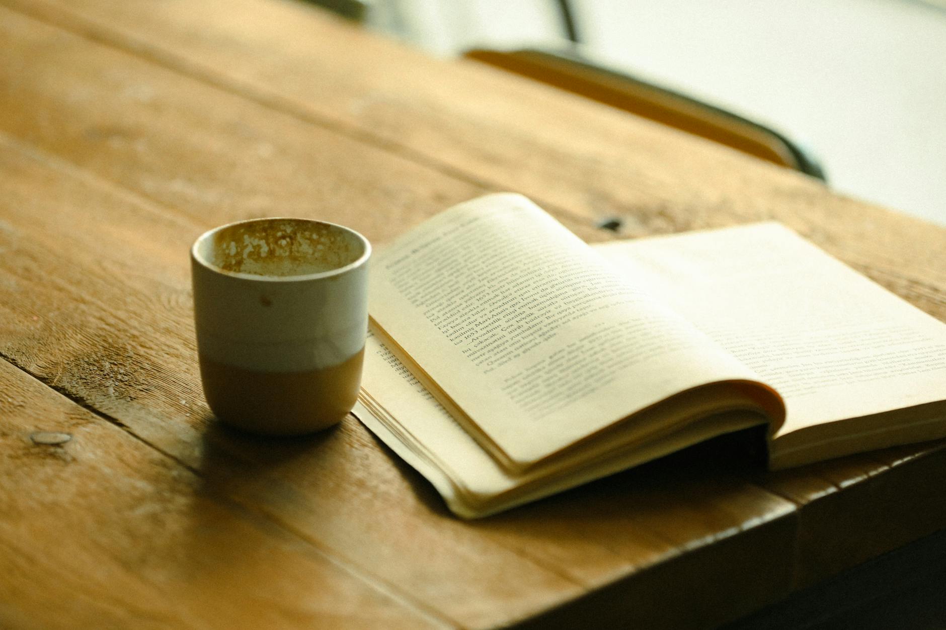 Person reading poetry book in cozy cafe setting