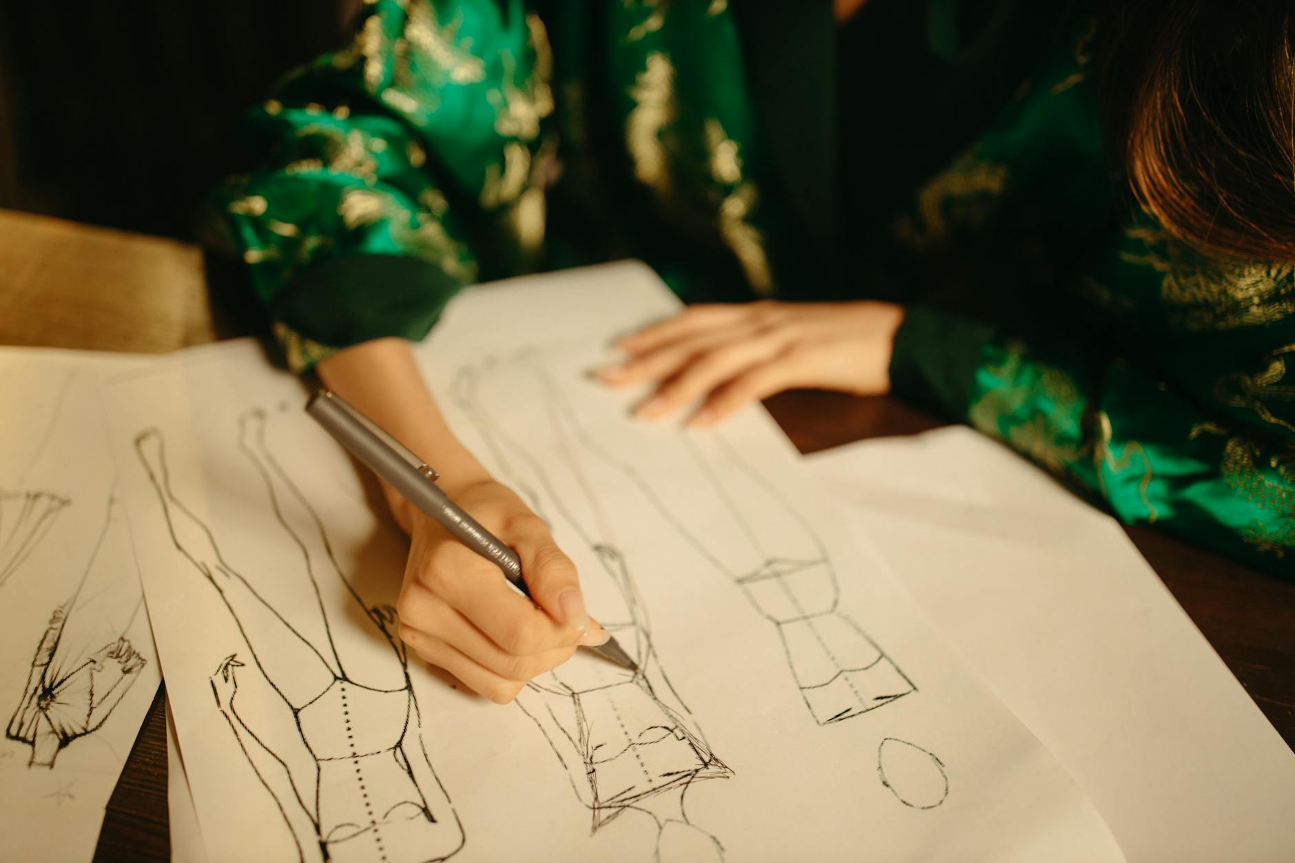 Fashion designer working on gender-neutral clothing sketches at a design studio