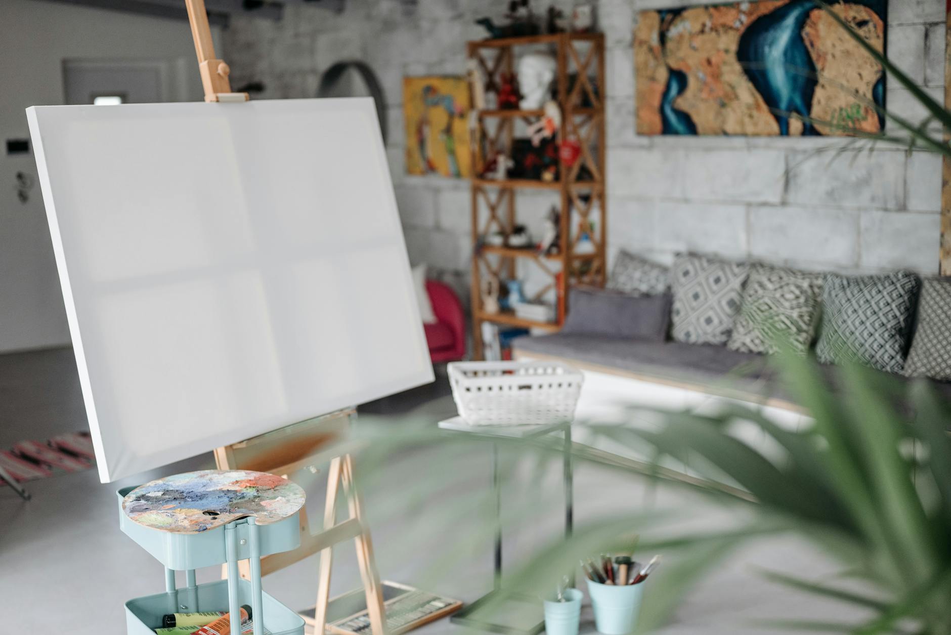 Artist painting on canvas with brushes and palette in a traditional art studio