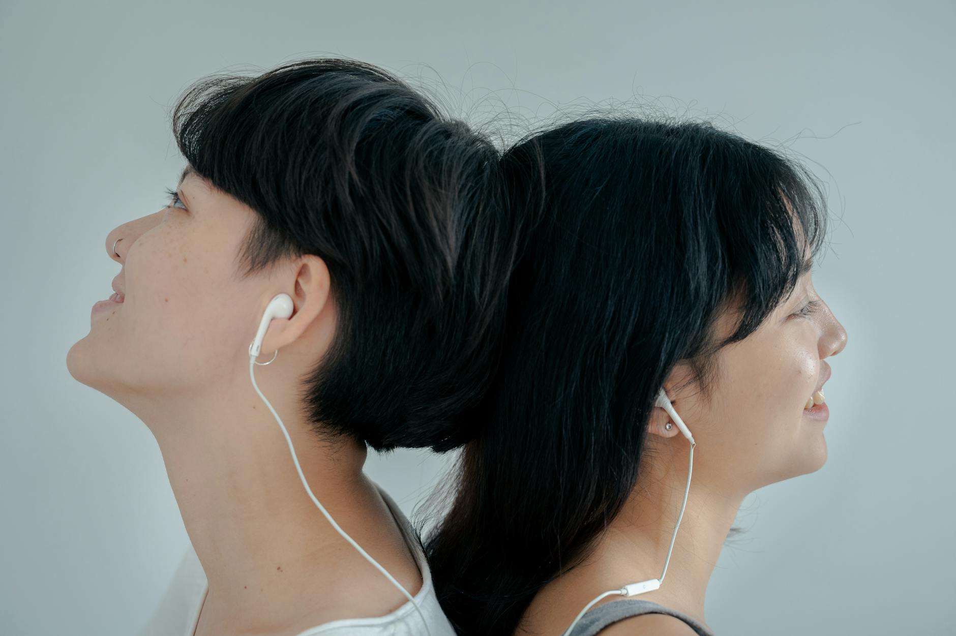 Group of young adults sitting in a circle, focused on listening to music together in a cozy living room setting