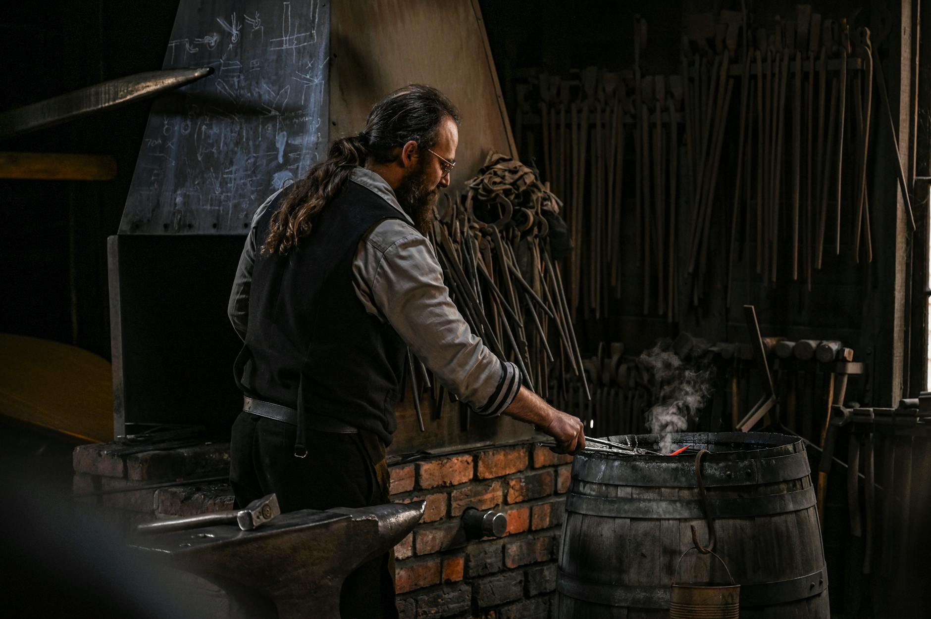 Traditional blacksmith working at forge demonstrating historical metalworking techniques