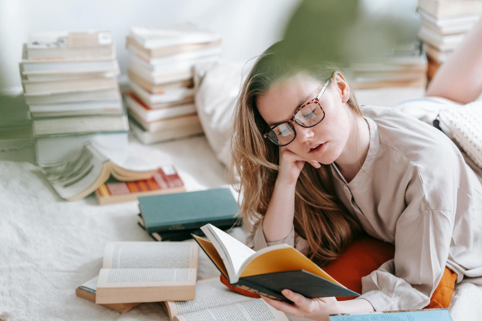 Woman sitting comfortably reading a book in natural lighting