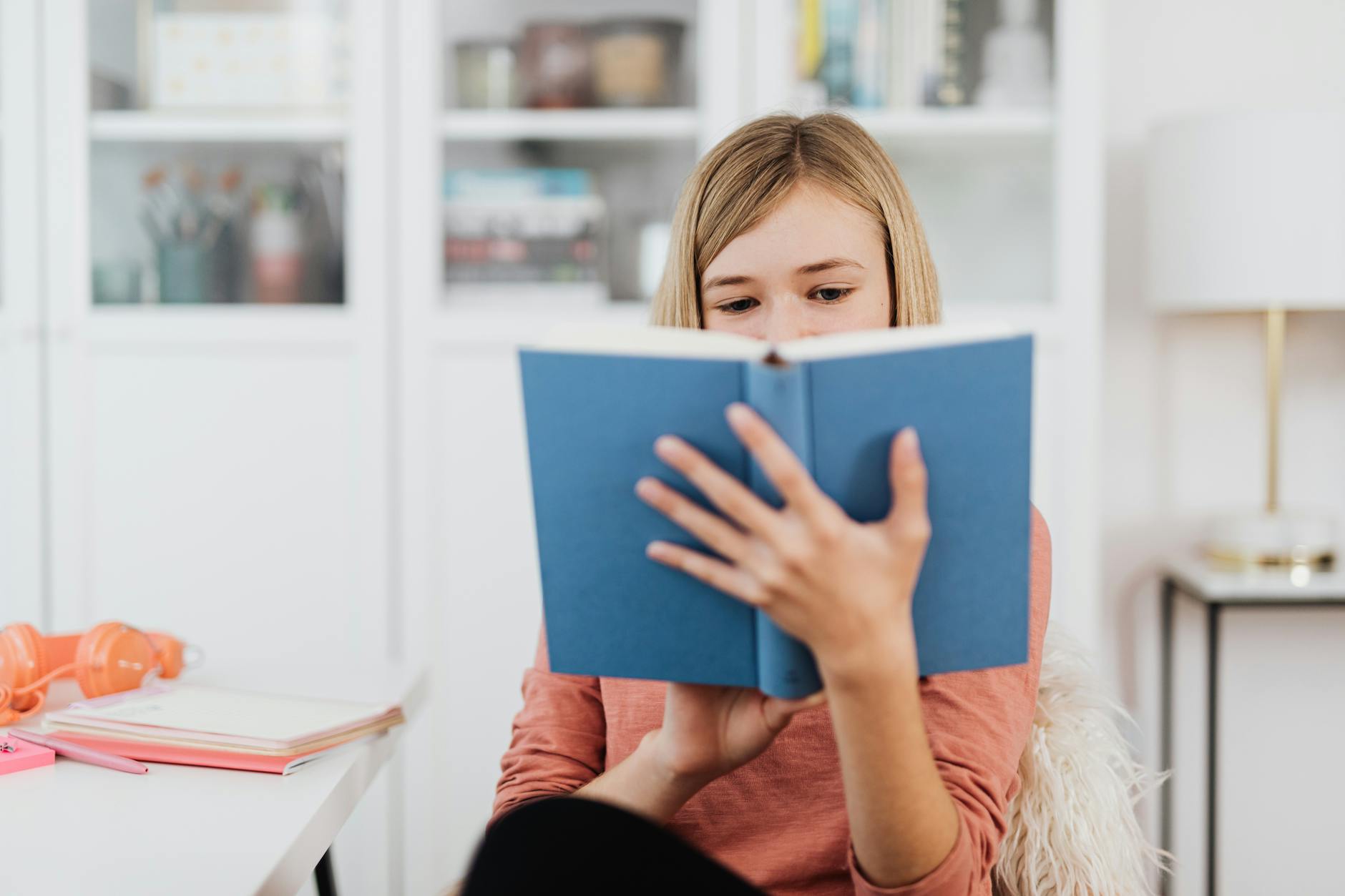 Young person reading a book in natural lighting