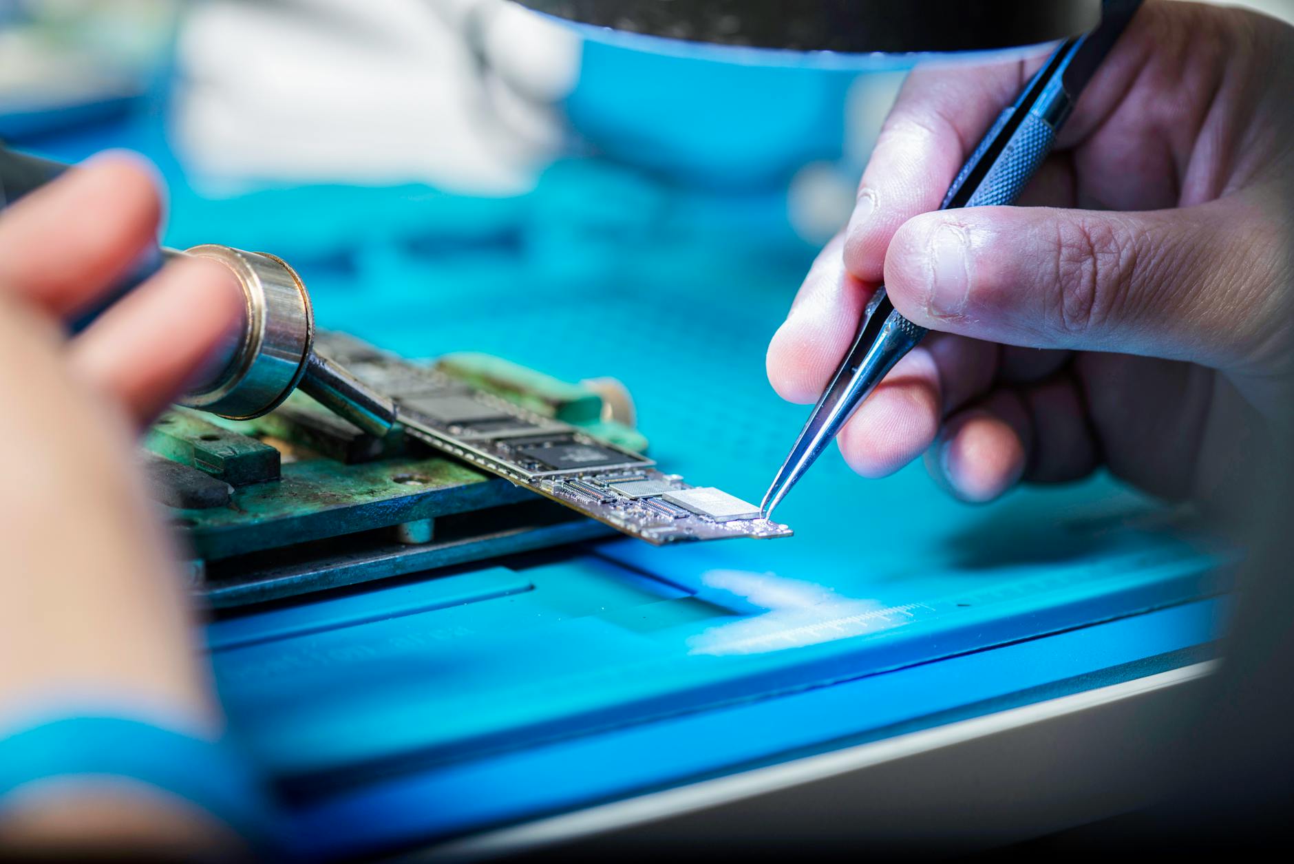 Person repairing or assembling smartphone components on a work surface