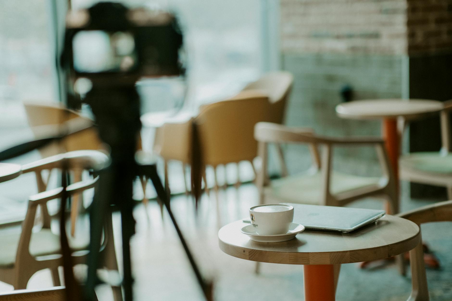 Person working on tablet with keyboard in modern cafe environment