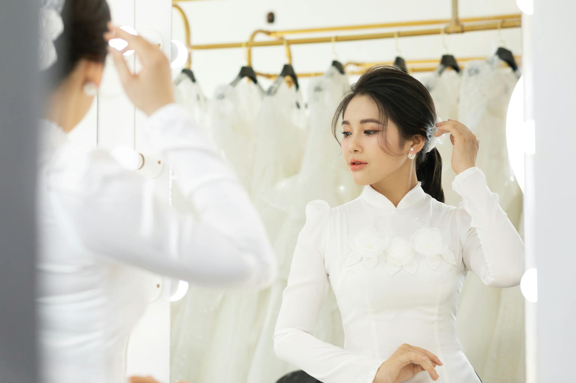 Bride trying on wedding dress in fitting room with mirror