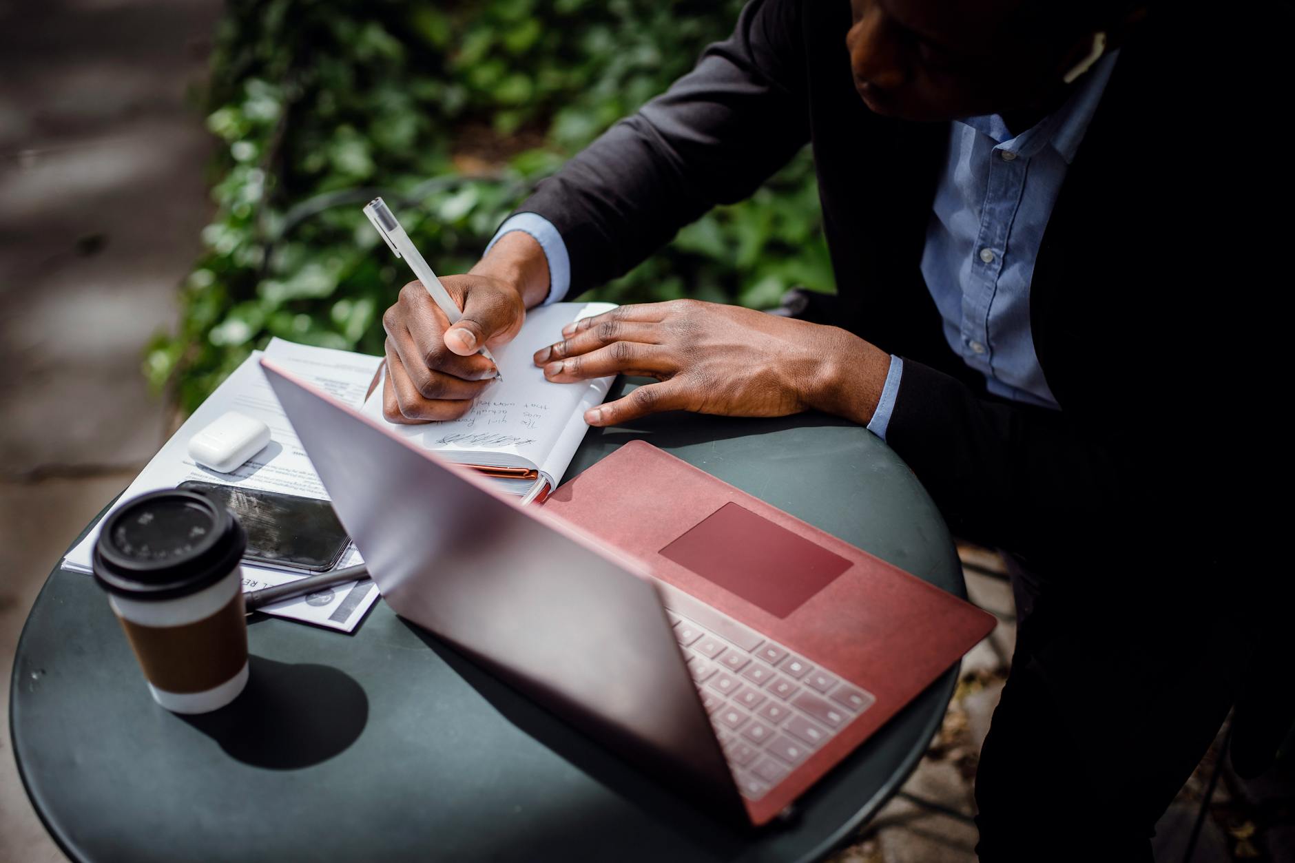 Author writing on laptop with coffee cup in cozy workspace