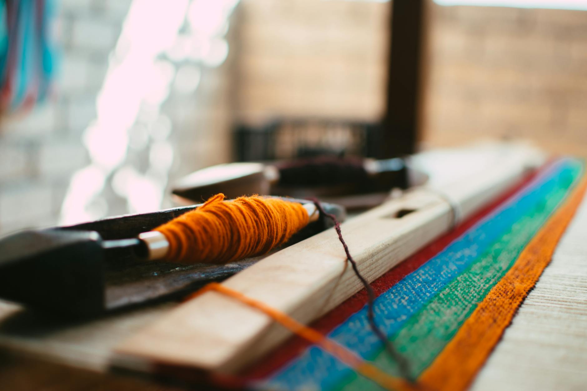 Hands working on detailed fabric stitching and patchwork with various colorful materials and thread