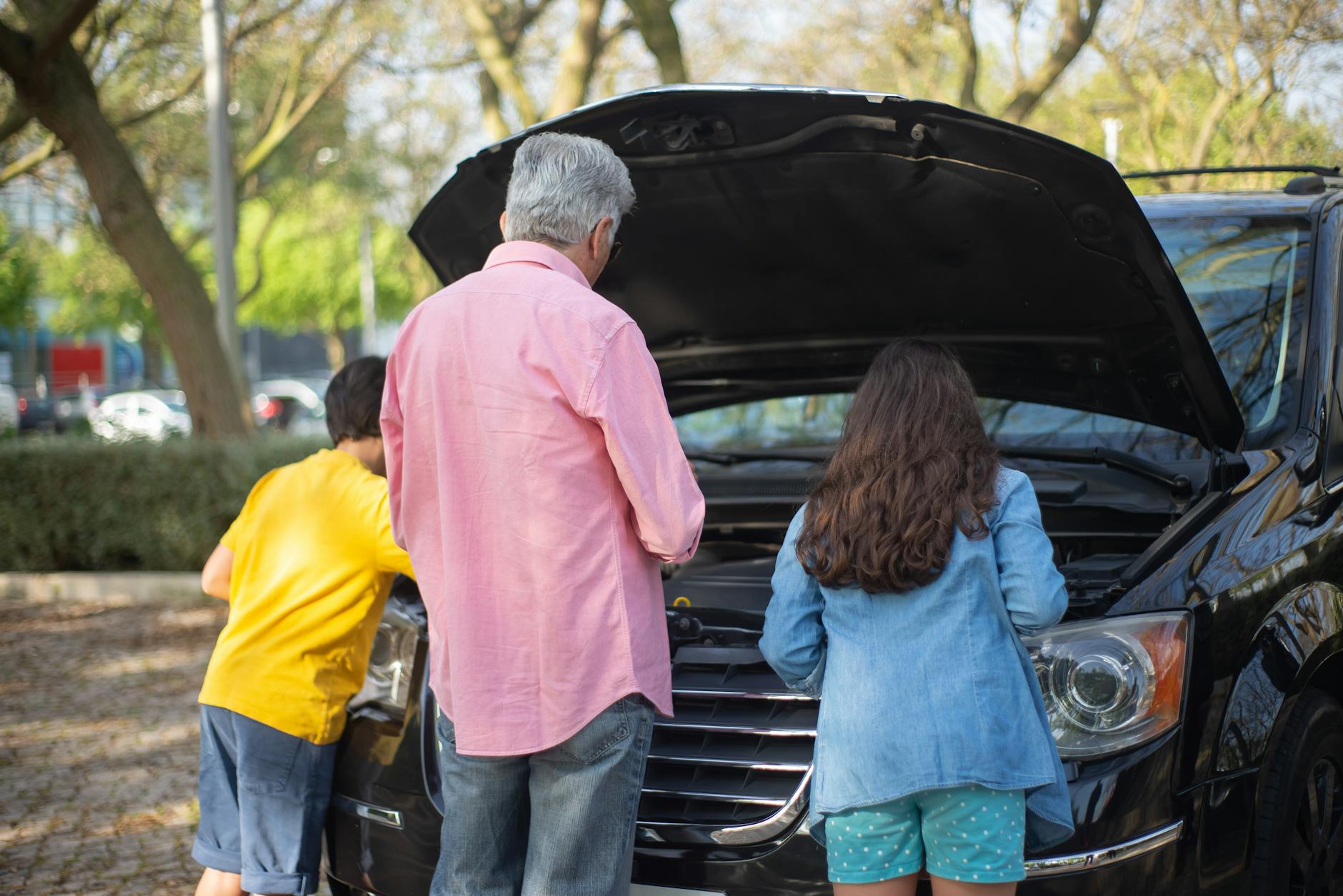 Family sitting in car during evening entertainment event with warm lighting