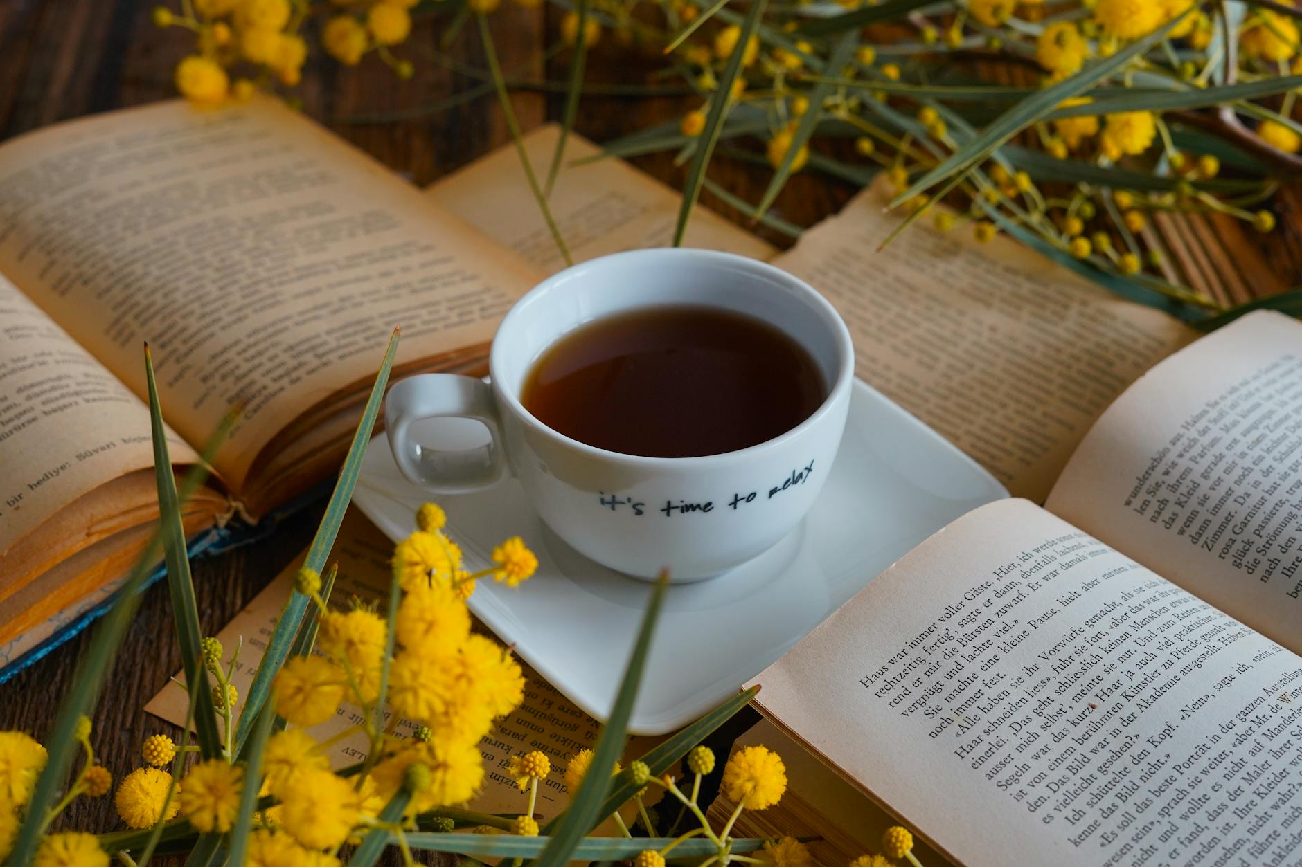 Cup of tea next to an open book, symbolizing the comfort and coziness of the mystery genre