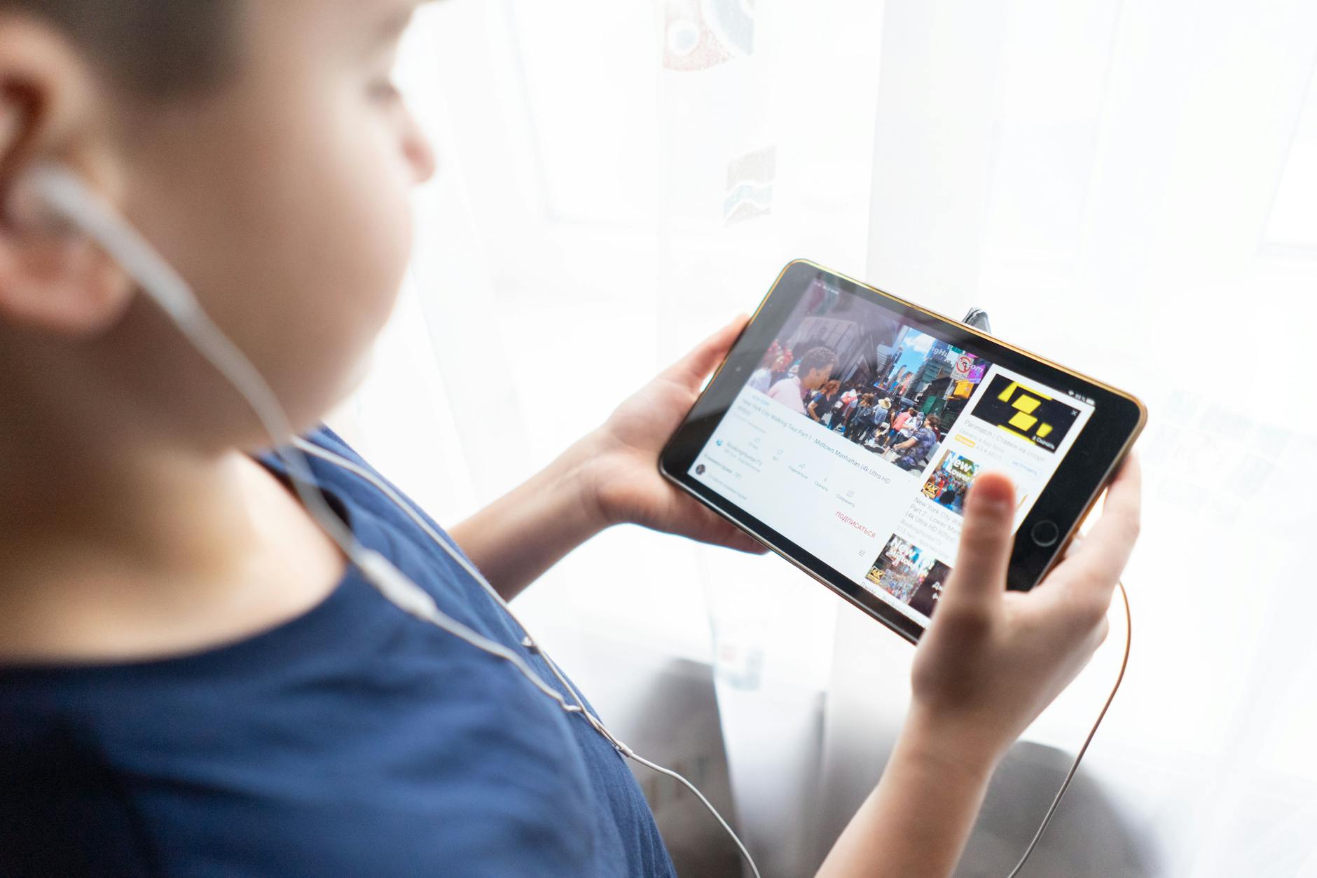 Person watching streaming content on tablet device showing video interface