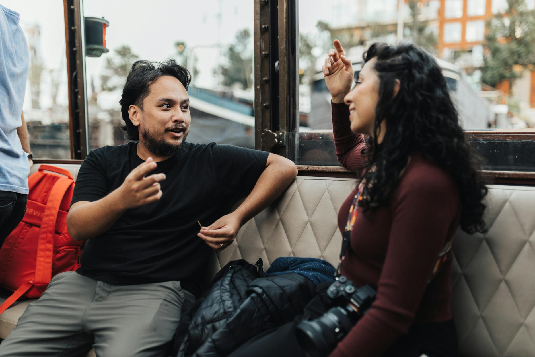 Two people having a friendly conversation while traveling, representing cross-cultural communication
