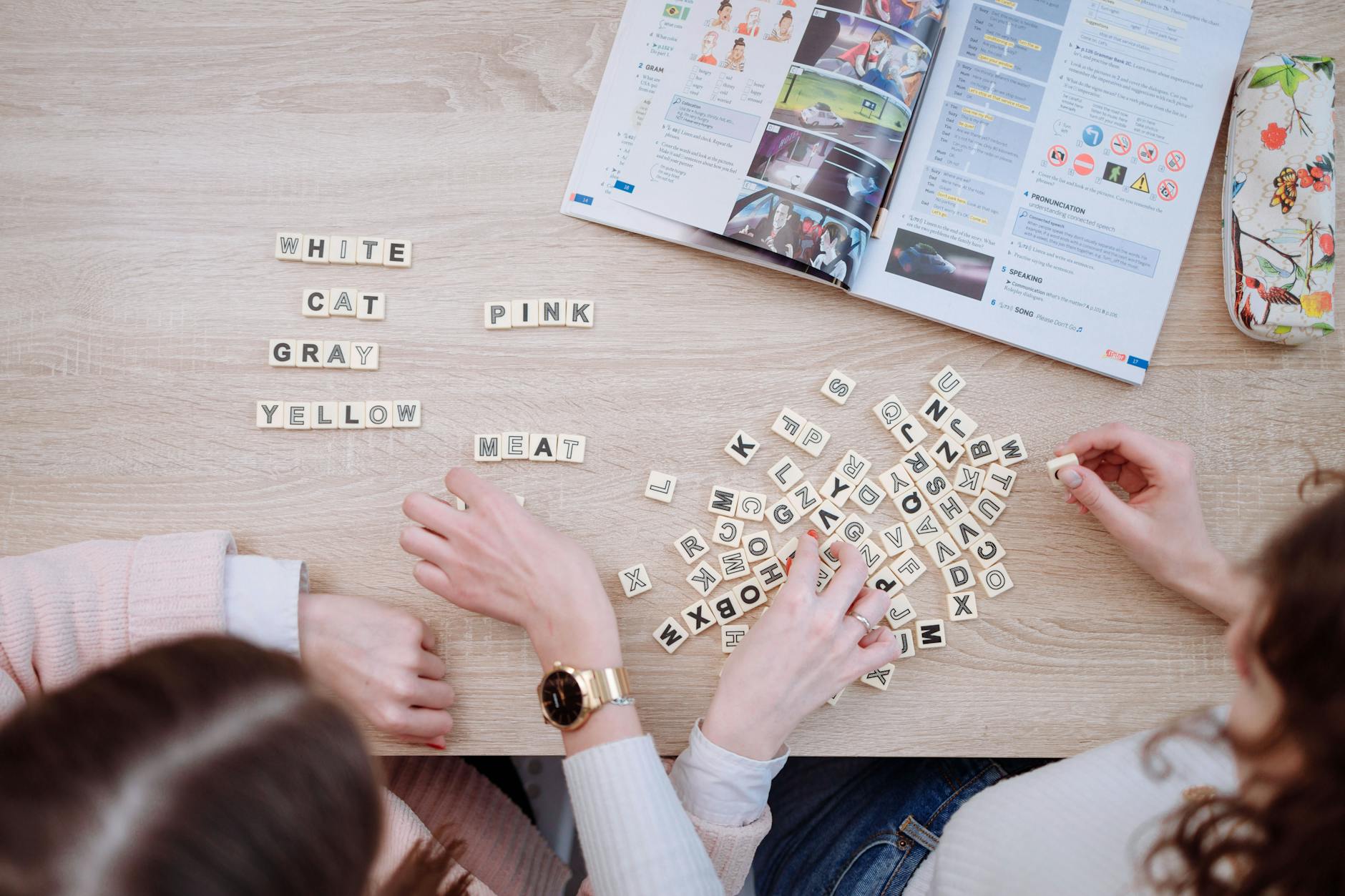Close-up of open books with puzzle pieces and magnifying glass suggesting literary mystery solving