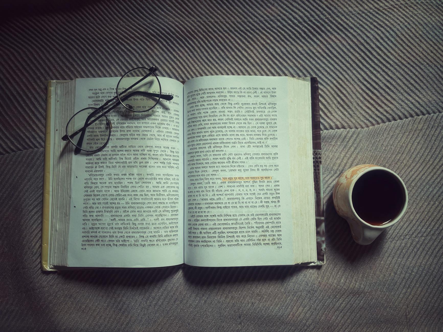 Stack of books next to a coffee cup creating an inviting reading atmosphere