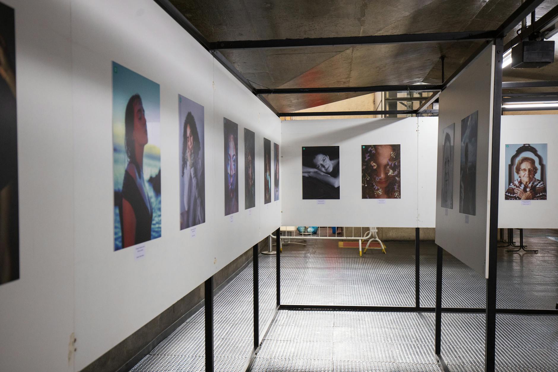 Contemporary art gallery space with visitors viewing modern paintings and sculptures in atmospheric lighting