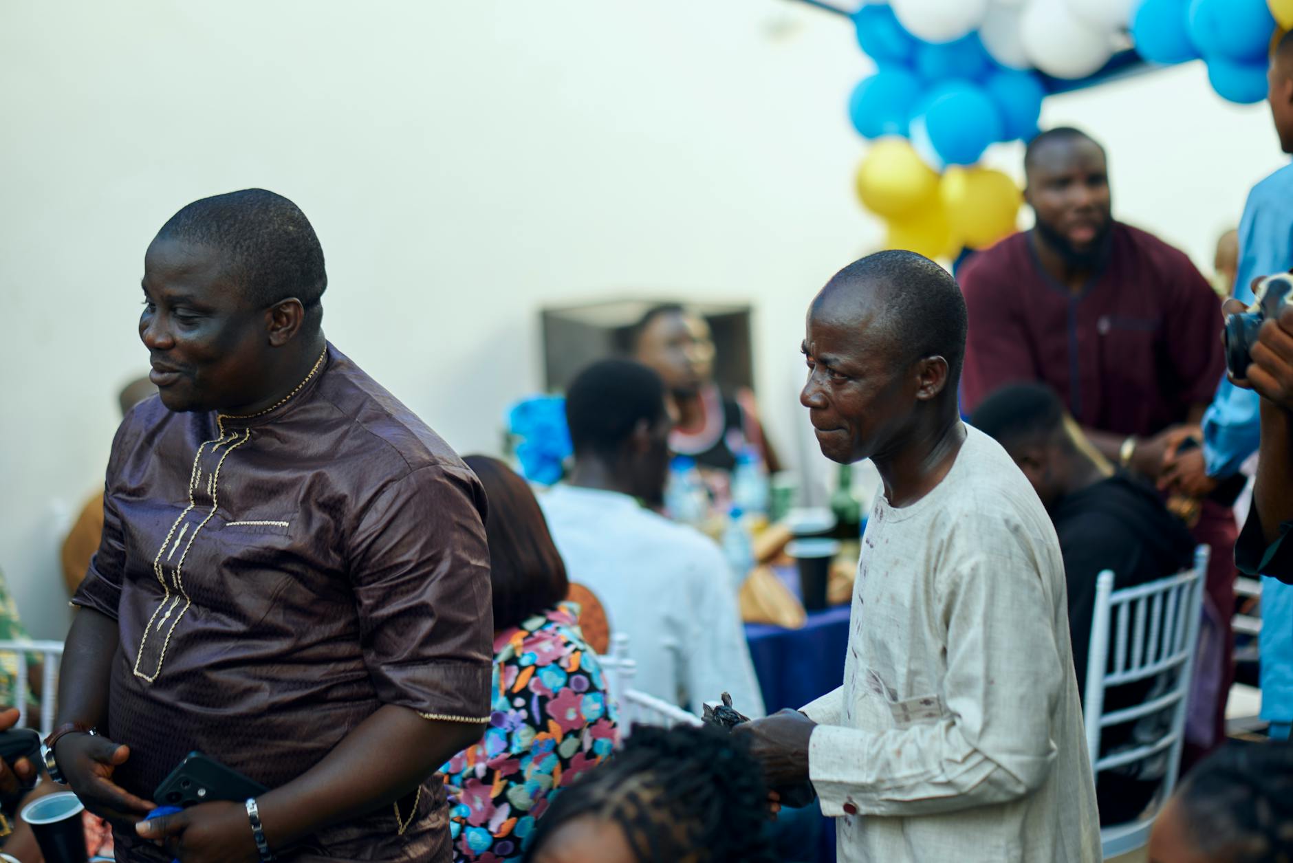 Group of diverse people sitting together at a table in a cafe, engaged in conversation and smiling