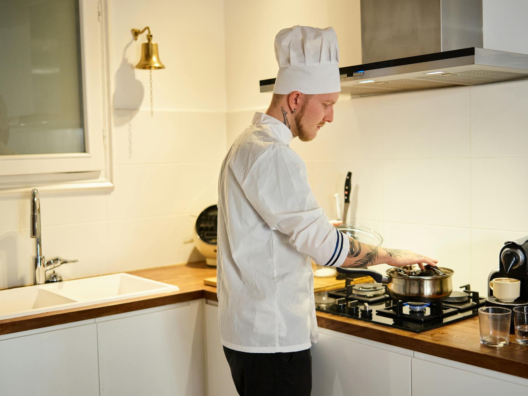 Professional chef demonstrating cooking technique to students in culinary classroom