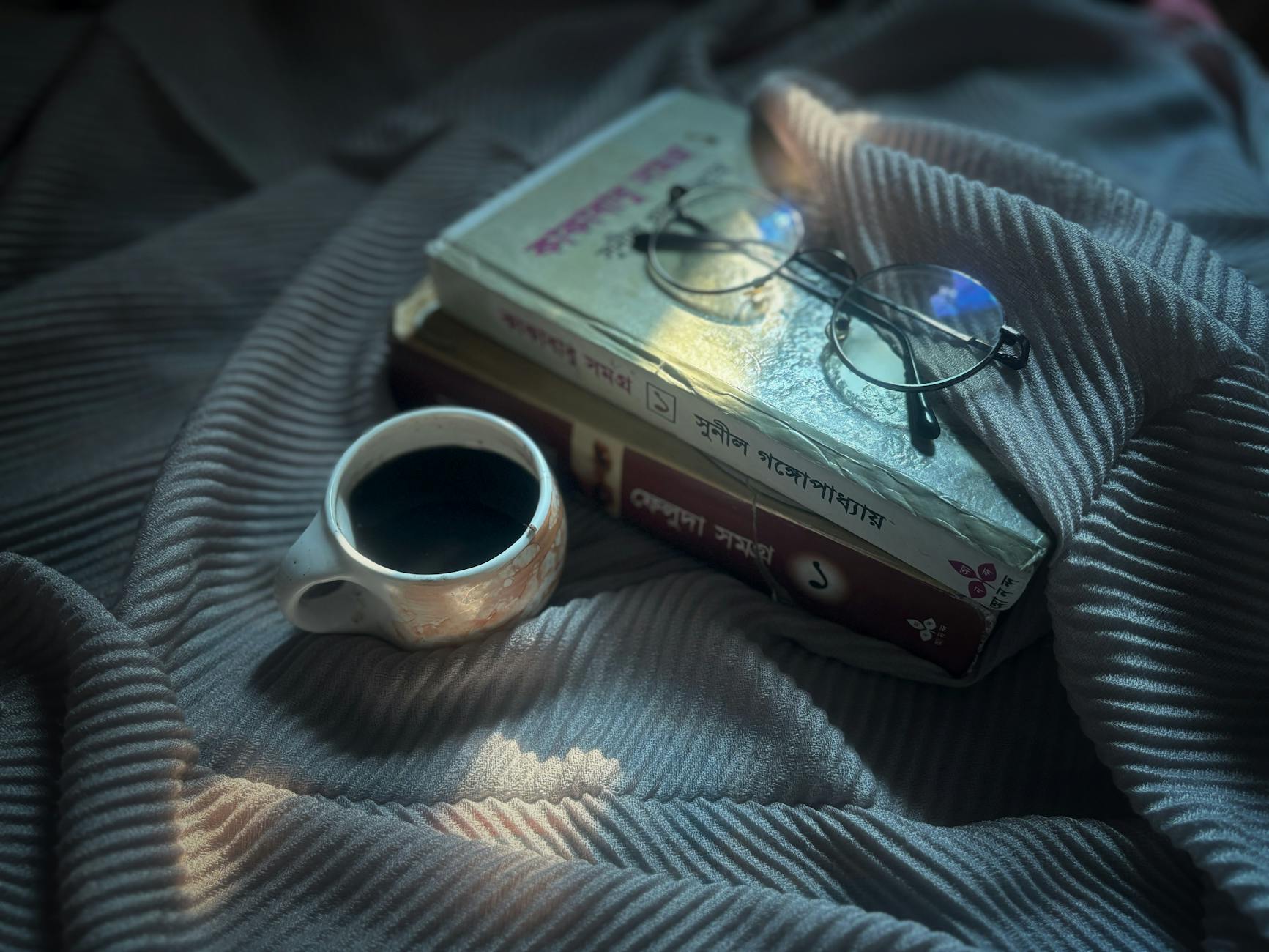 Open books and coffee cups on a wooden table suggesting reading gathering
