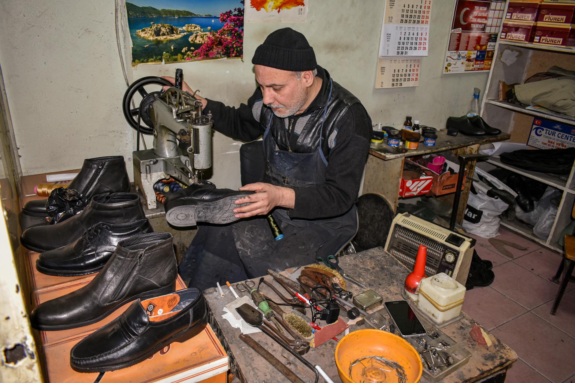 Cobbler working on shoe repair at professional workstation