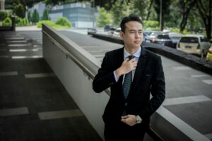 Professional businessman adjusting necktie in office setting