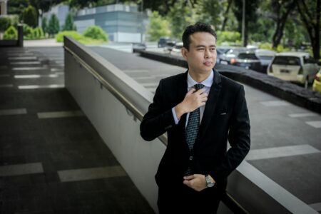 Professional businessman adjusting necktie in office setting